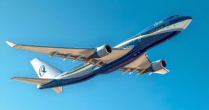 A sleek Boeing 747 jet in a vibrant blue and white color scheme surrounded by a clear sky.
