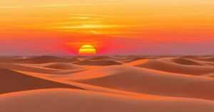 A serene landscape featuring a vast desert at sunset, with warm color tones and abstract impressionist style.
