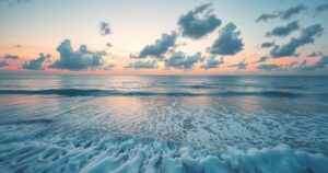 Partly cloudy sky over Pensacola Beach with soft waves and calm weather.