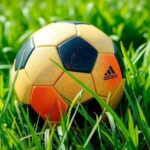 Colorful soccer ball on a lush green field, representing excitement of the game, in a vibrant and lively style.