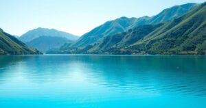 A serene landscape showing a clear blue lake surrounded by lush greenery, emphasizing the importance of clean water access.